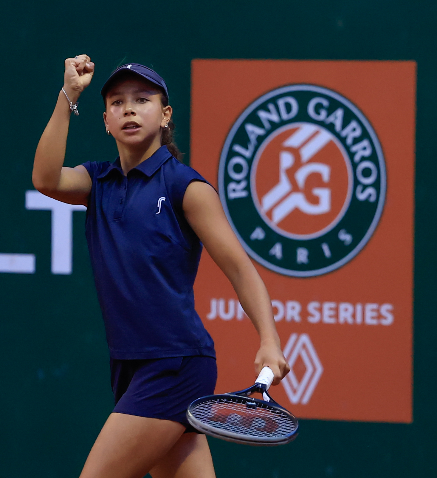 Eduarda Gomes no Roland-Garros Junior Series, punho cerrado e raquete na mão